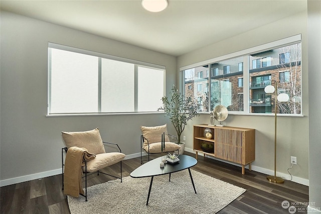 living area with baseboards and wood finished floors