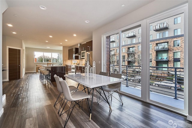 dining room with recessed lighting, baseboards, and dark wood-type flooring