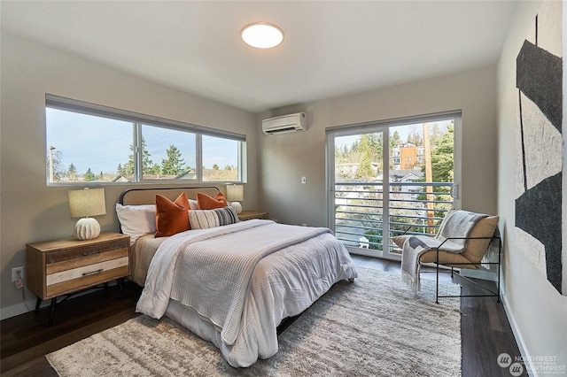 bedroom with a wall unit AC, access to outside, wood finished floors, and baseboards