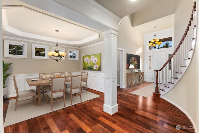 dining room with dark wood-type flooring, crown molding, a tray ceiling, and a notable chandelier