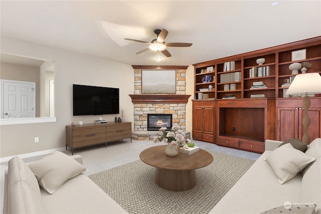 carpeted living room with ceiling fan and a fireplace