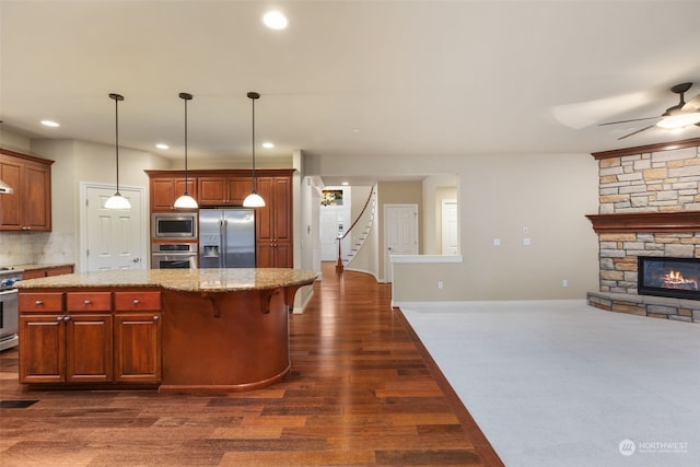 kitchen featuring decorative light fixtures, a center island, stainless steel appliances, and tasteful backsplash