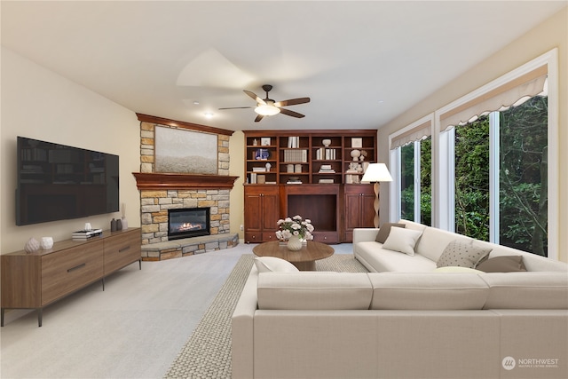 living room with ceiling fan, built in shelves, and a fireplace