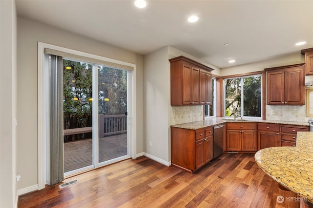 kitchen with light stone countertops, backsplash, dishwasher, and dark hardwood / wood-style flooring