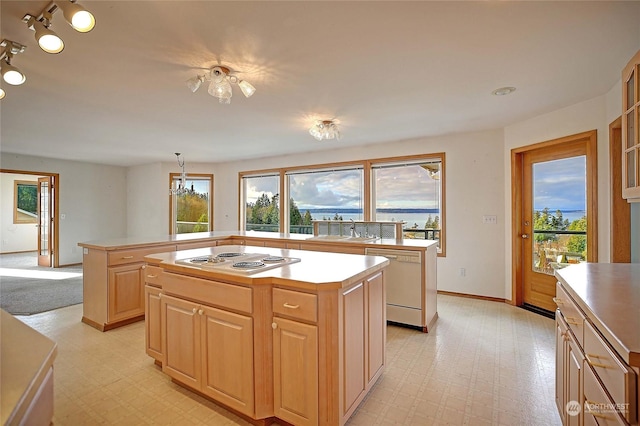 kitchen with sink, a center island, plenty of natural light, and dishwasher