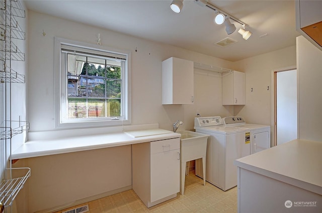 laundry room with cabinets, washing machine and clothes dryer, and rail lighting