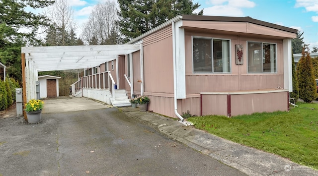 view of property exterior featuring a lawn, a storage unit, and a carport