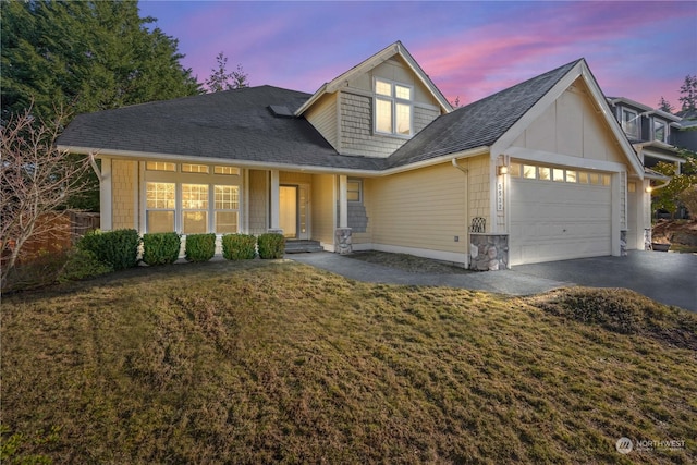 view of front of home with a garage and a lawn