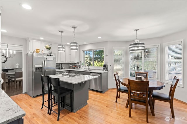 kitchen featuring hanging light fixtures, appliances with stainless steel finishes, and a kitchen island