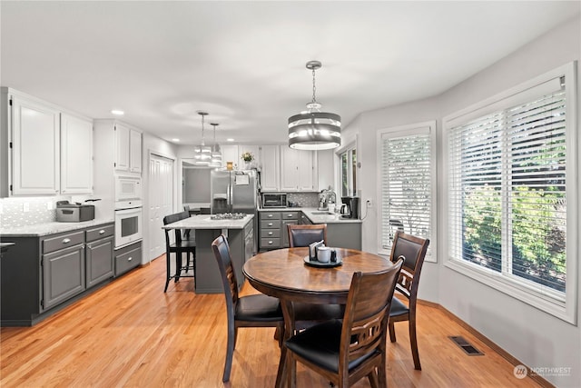 dining room with sink and light wood-type flooring