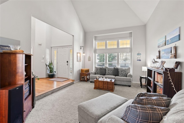 living room with high vaulted ceiling and carpet