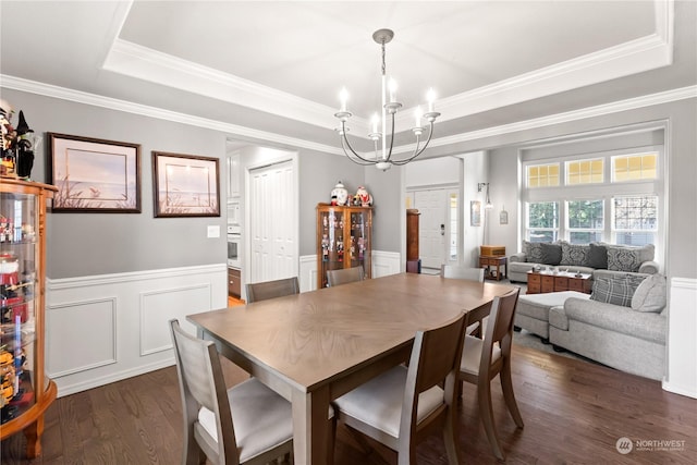 dining space featuring crown molding, dark hardwood / wood-style floors, a notable chandelier, and a tray ceiling