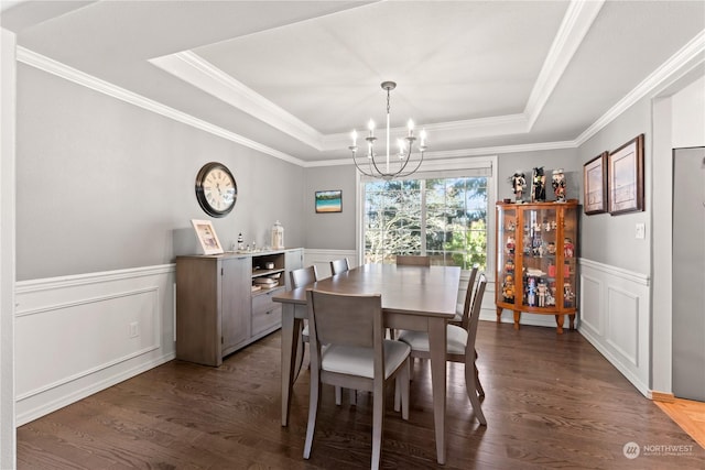 dining area featuring crown molding, a chandelier, dark hardwood / wood-style floors, and a tray ceiling