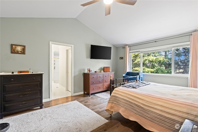 bedroom featuring ceiling fan, connected bathroom, light hardwood / wood-style floors, and lofted ceiling