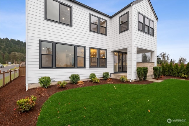 rear view of property featuring a lawn