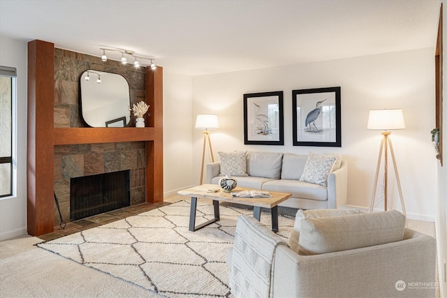 living room with a tile fireplace and track lighting