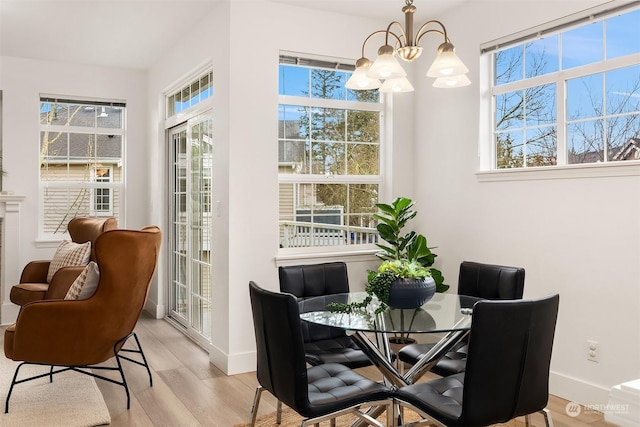 dining area featuring light hardwood / wood-style flooring and a chandelier