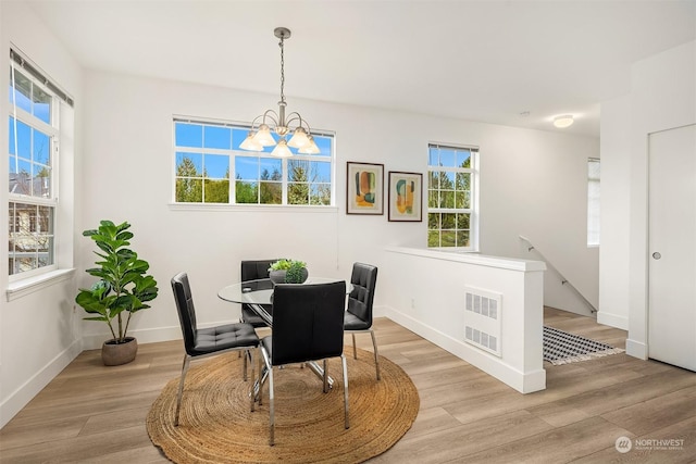 dining area featuring light hardwood / wood-style floors and a notable chandelier