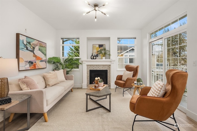 interior space featuring an inviting chandelier, light hardwood / wood-style floors, and a tile fireplace