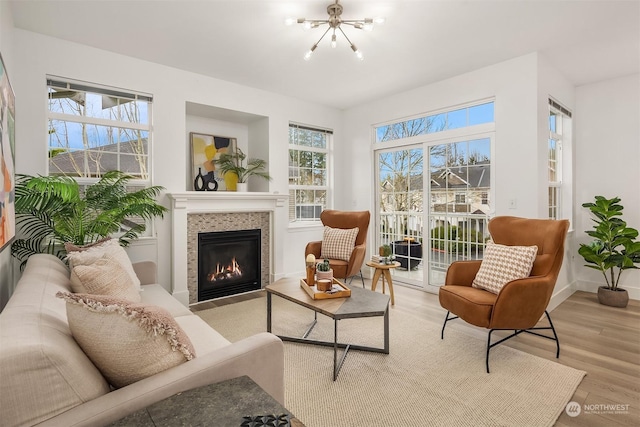 sunroom featuring a tile fireplace and a chandelier