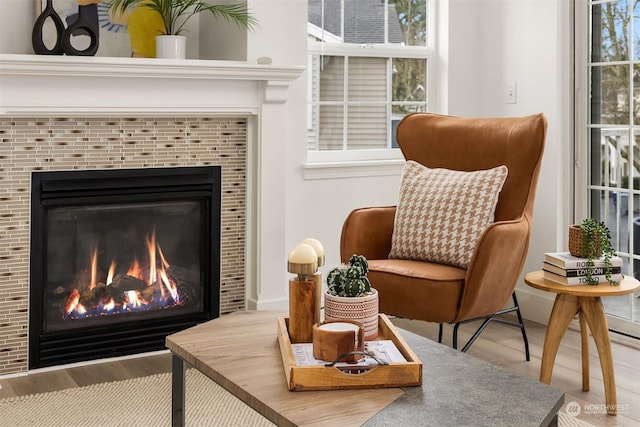 living area featuring a healthy amount of sunlight and a tile fireplace