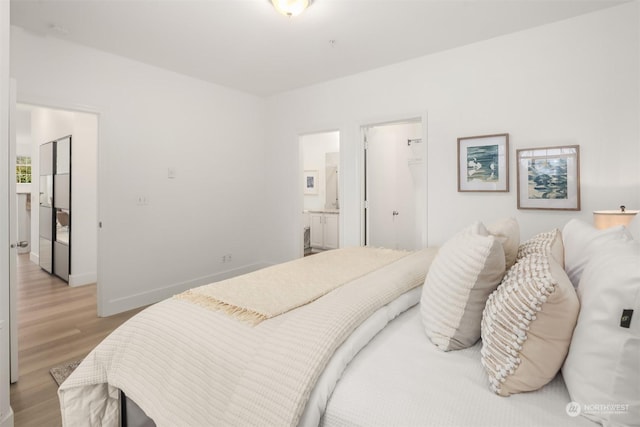 bedroom with ensuite bathroom and light wood-type flooring