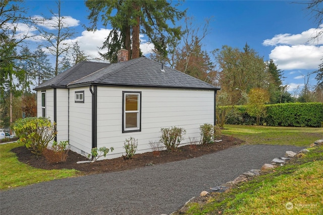 view of side of home with a yard