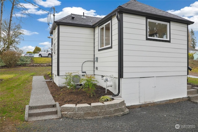 view of side of property with a lawn and ac unit