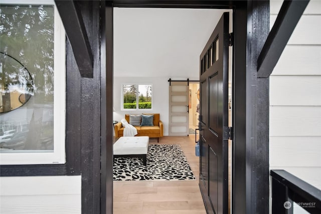 doorway with a barn door and light hardwood / wood-style flooring