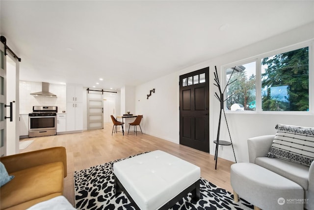 living room featuring light hardwood / wood-style floors and a barn door