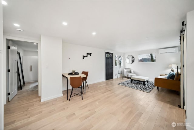 living room featuring light hardwood / wood-style flooring and a wall mounted air conditioner