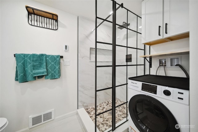 interior space with washer / dryer, toilet, tile patterned floors, and tiled shower