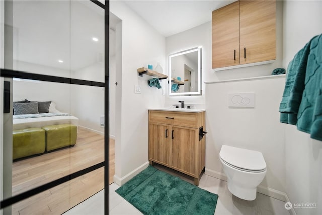 bathroom with toilet, vanity, and tile patterned flooring