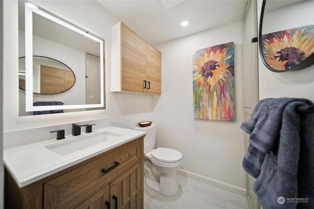 bathroom with toilet, vanity, and tile patterned flooring