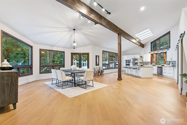 dining space featuring vaulted ceiling with beams and light hardwood / wood-style floors