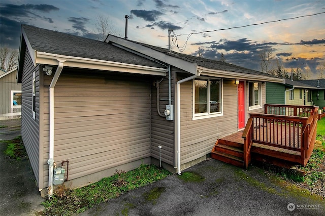 property exterior at dusk featuring a deck