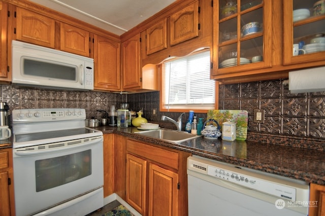 kitchen with decorative backsplash, sink, white appliances, and dark stone counters