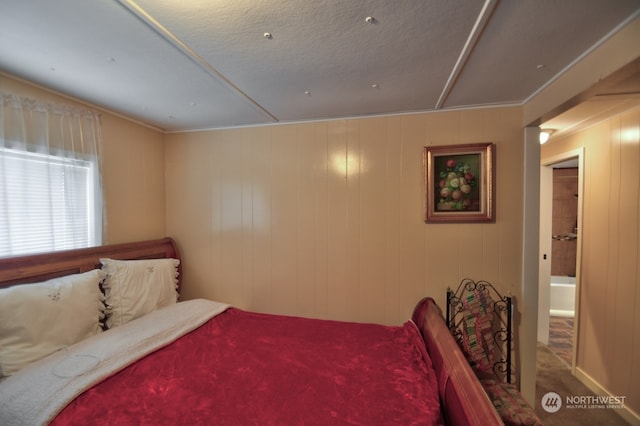 carpeted bedroom featuring wooden walls