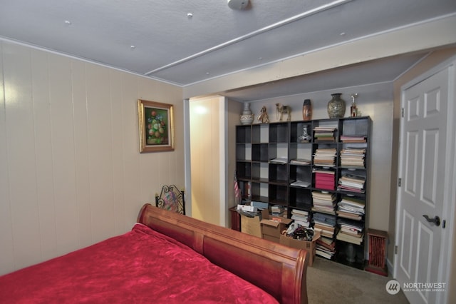 bedroom featuring carpet floors and wooden walls