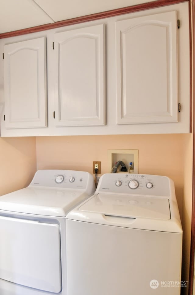 washroom featuring washer and dryer and cabinets