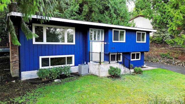 view of front facade with a front yard and central air condition unit