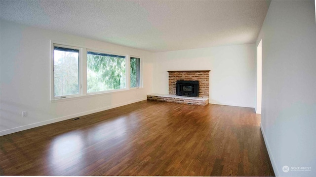 unfurnished living room featuring a textured ceiling and dark hardwood / wood-style flooring