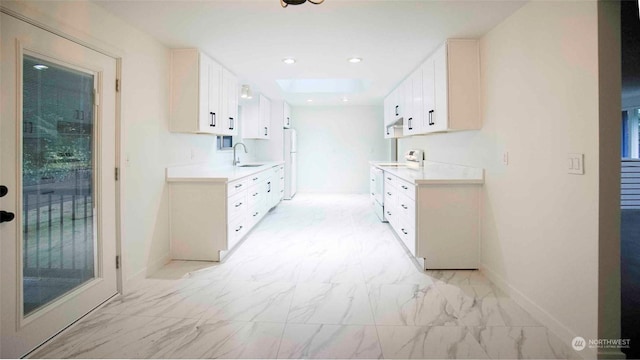 kitchen with white cabinetry, white refrigerator, a skylight, sink, and range with electric cooktop