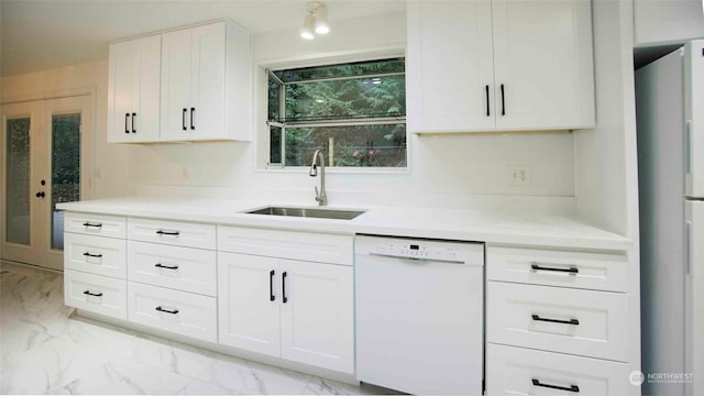 kitchen with french doors, sink, white appliances, and white cabinetry