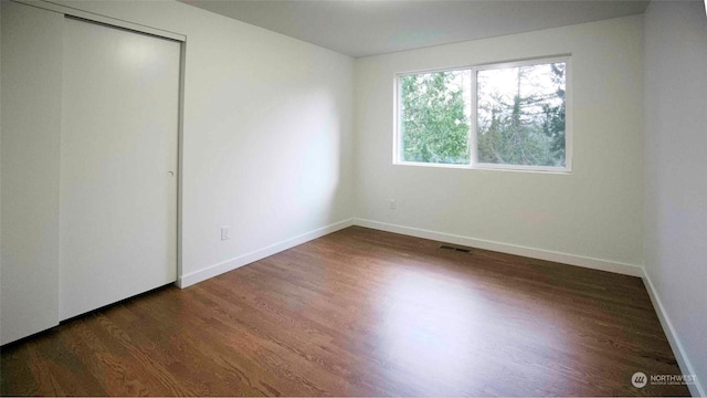 unfurnished bedroom featuring a closet and dark hardwood / wood-style floors