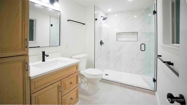 bathroom with a shower with shower door, vanity, tile patterned flooring, and toilet