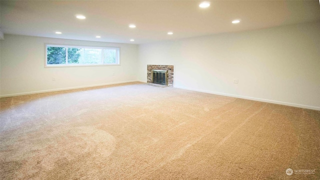 unfurnished living room with a brick fireplace and carpet flooring