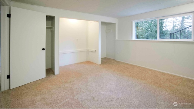 unfurnished bedroom with light carpet and a closet