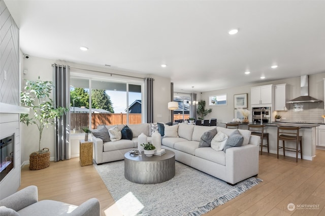 living room with light hardwood / wood-style floors, a chandelier, and plenty of natural light