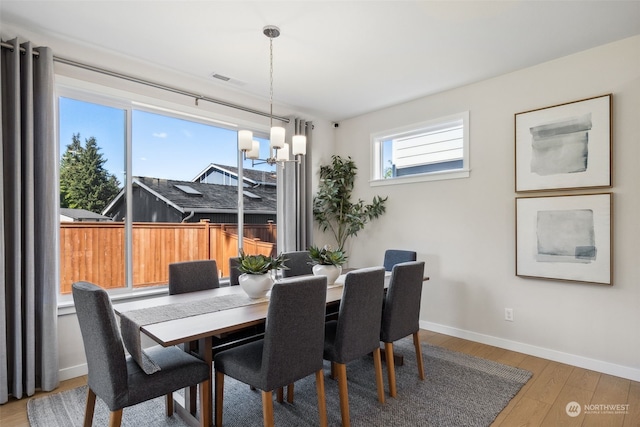 dining space with an inviting chandelier and wood-type flooring